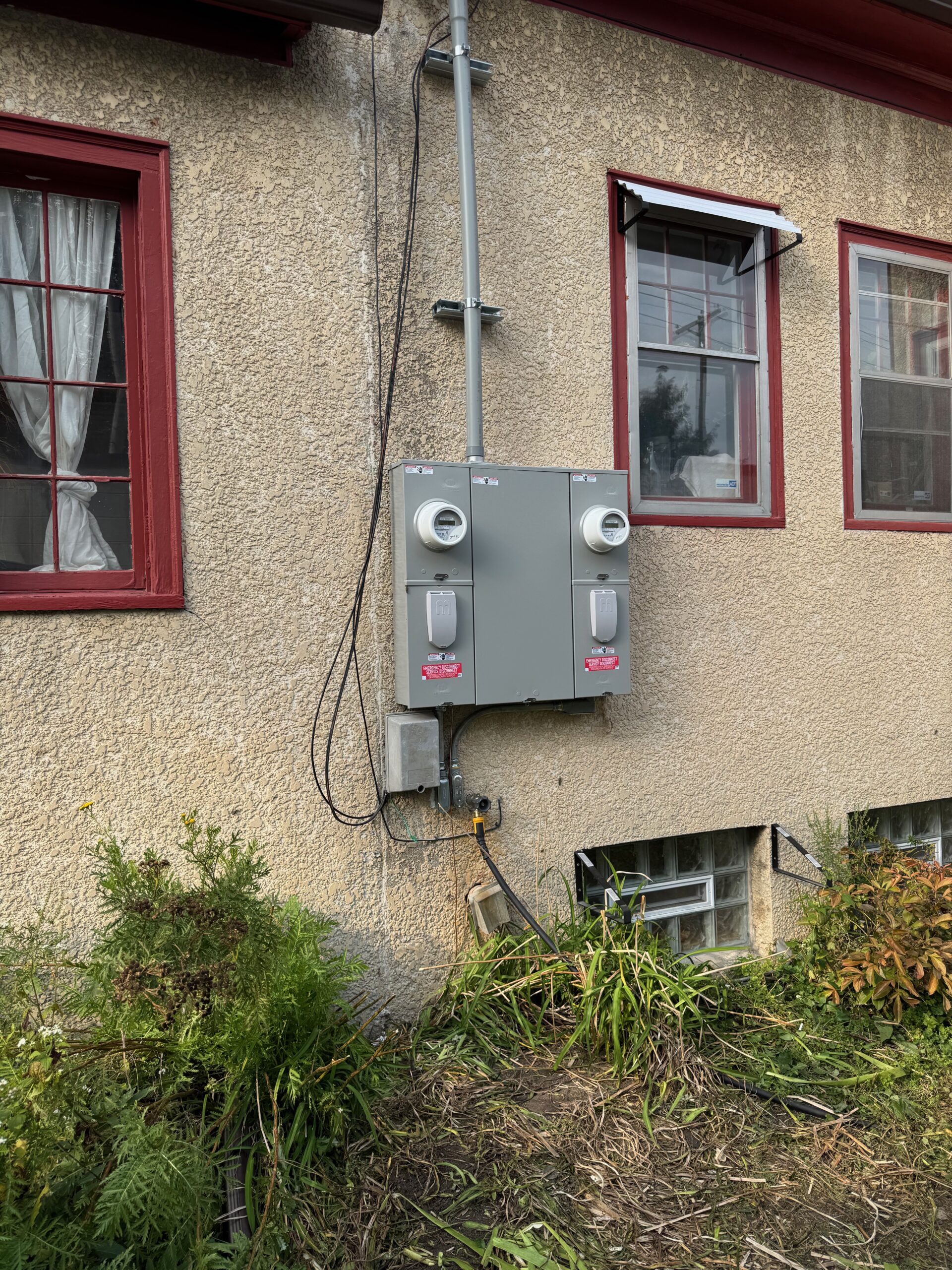 Two electric meters mounted side by side on the duplex exterior wall
