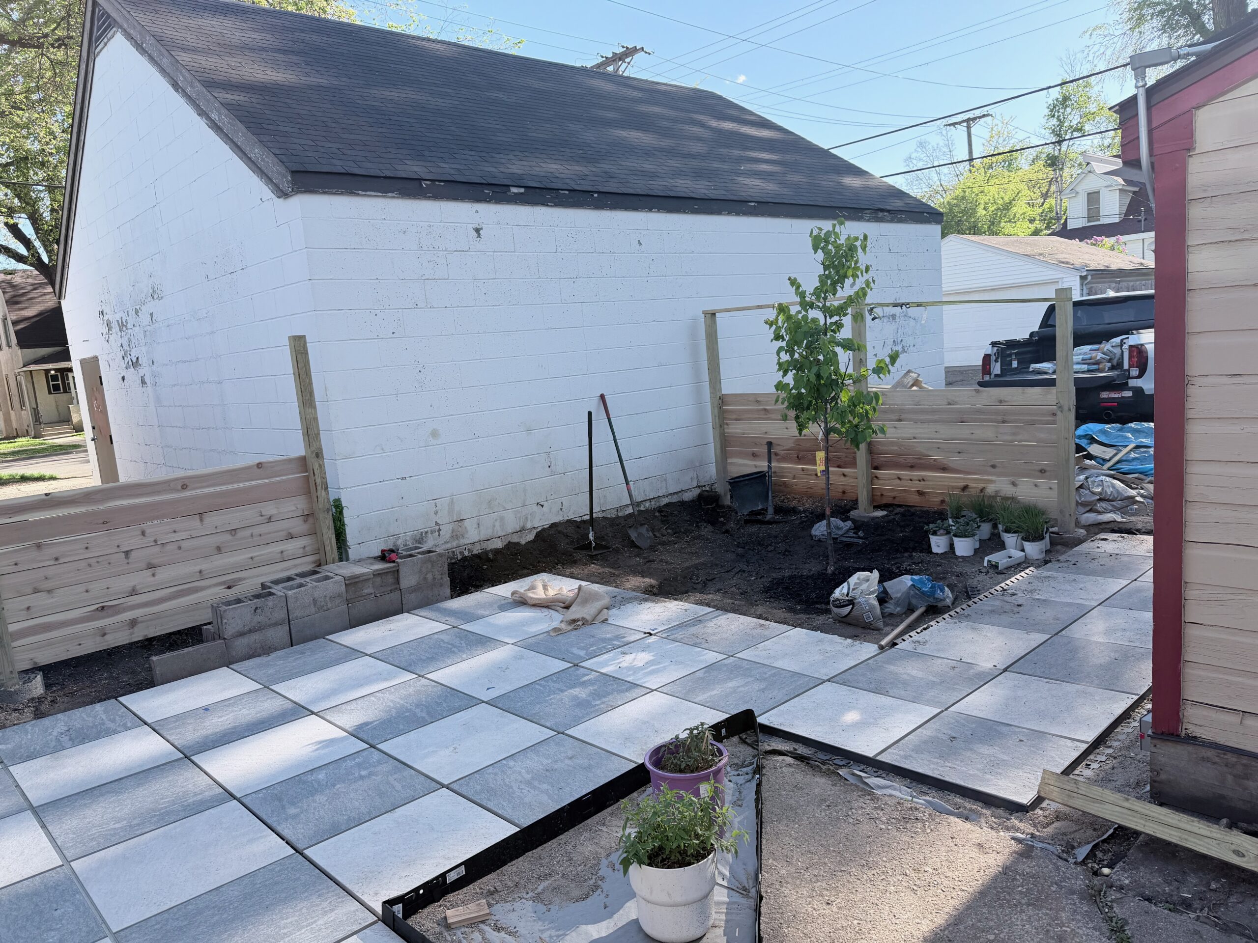 Duplex backyard mid-project with a new paver patio and cedar fence