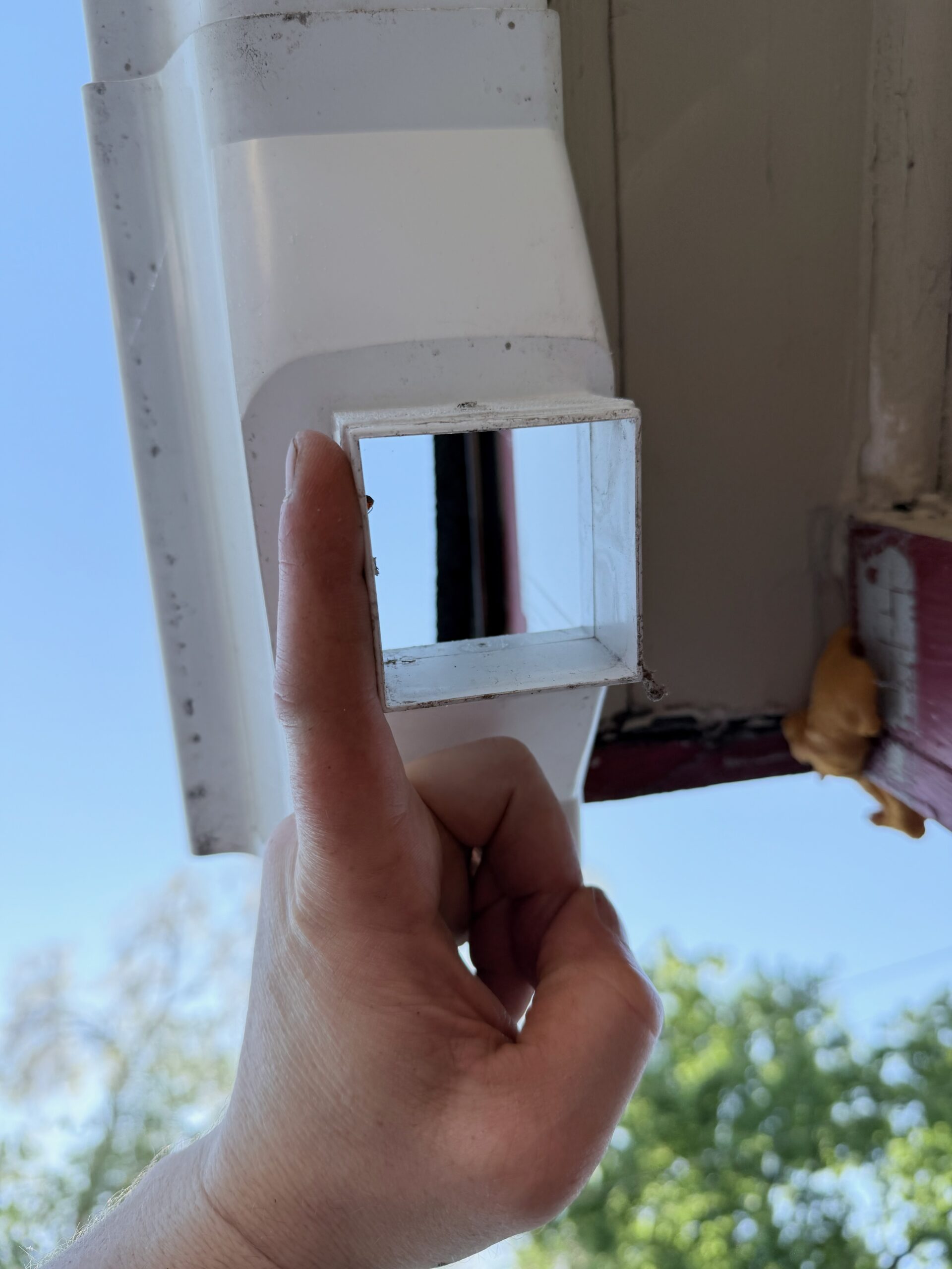 Hand-fitting a replacement downspout section on the duplex