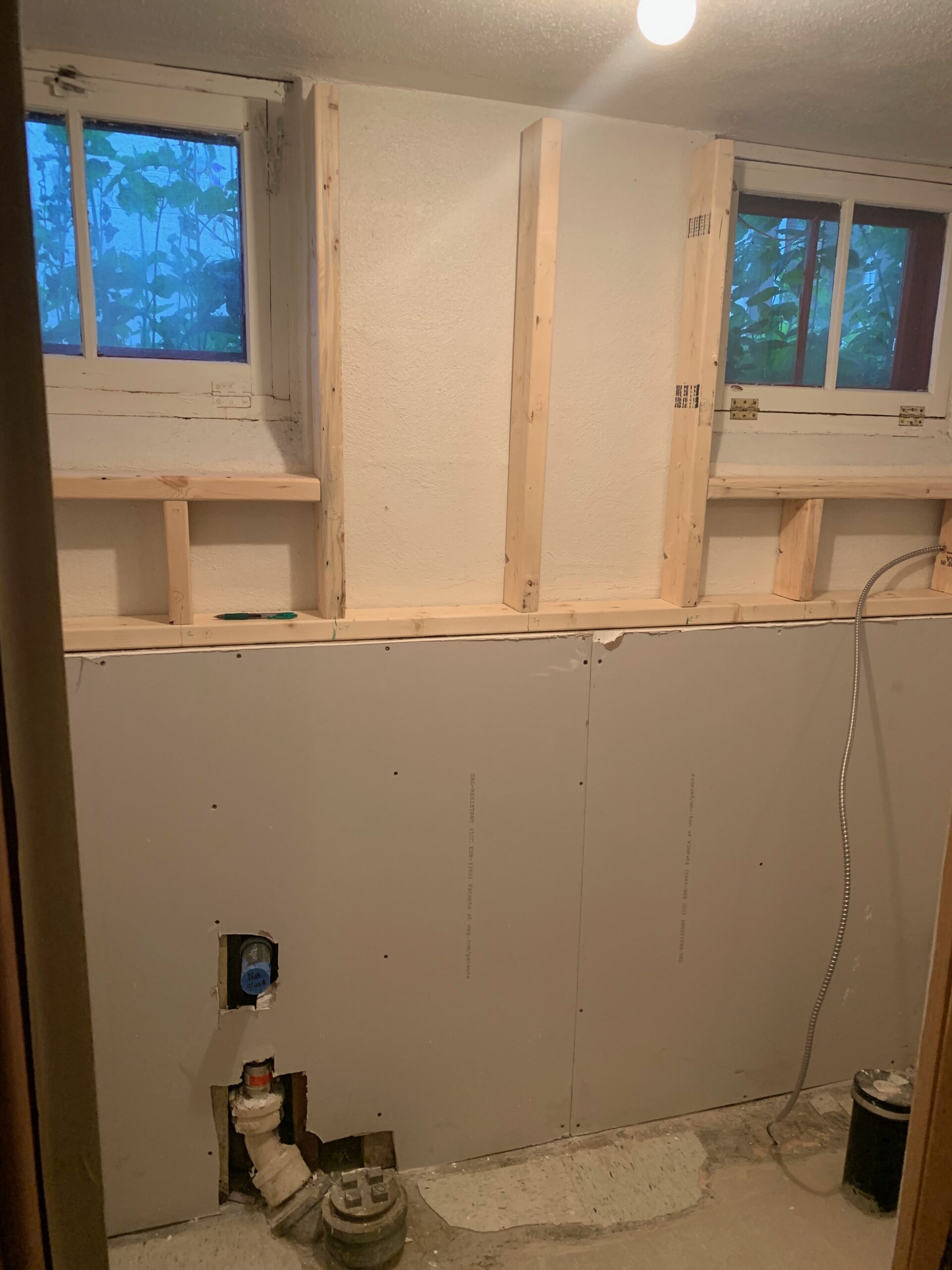 New framing, plumbing rough-in, and first sheets of drywall in the bathroom