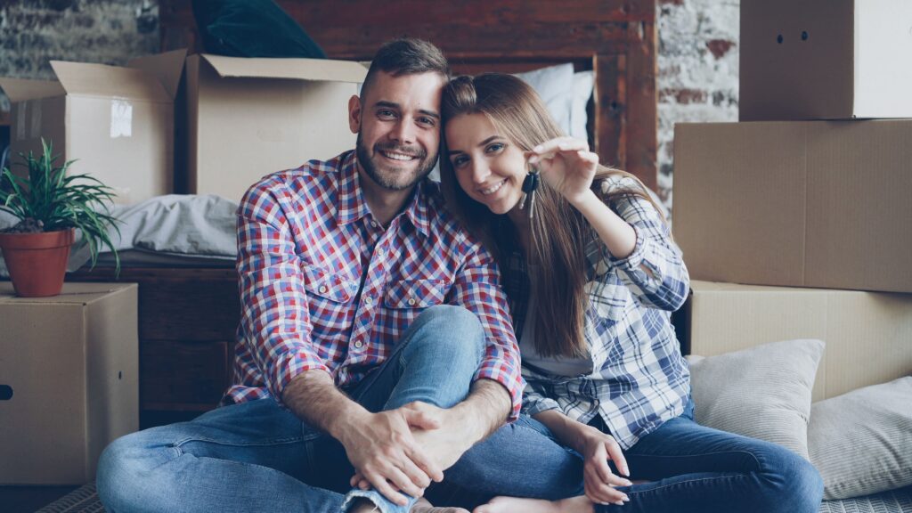 Stock photo of a happy couple holding house keys in their new home