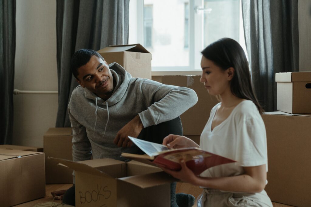 Stock photo of a couple smiling while unpacking boxes in a new home