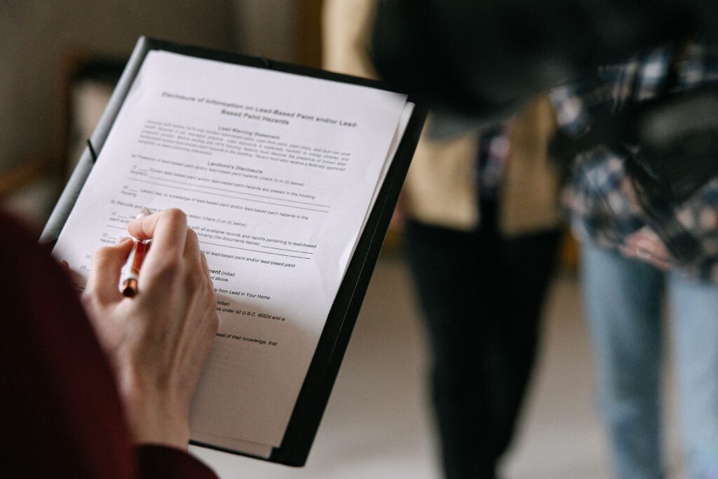 Stock photo flat-lay of a small house model and keys with a mortgage document