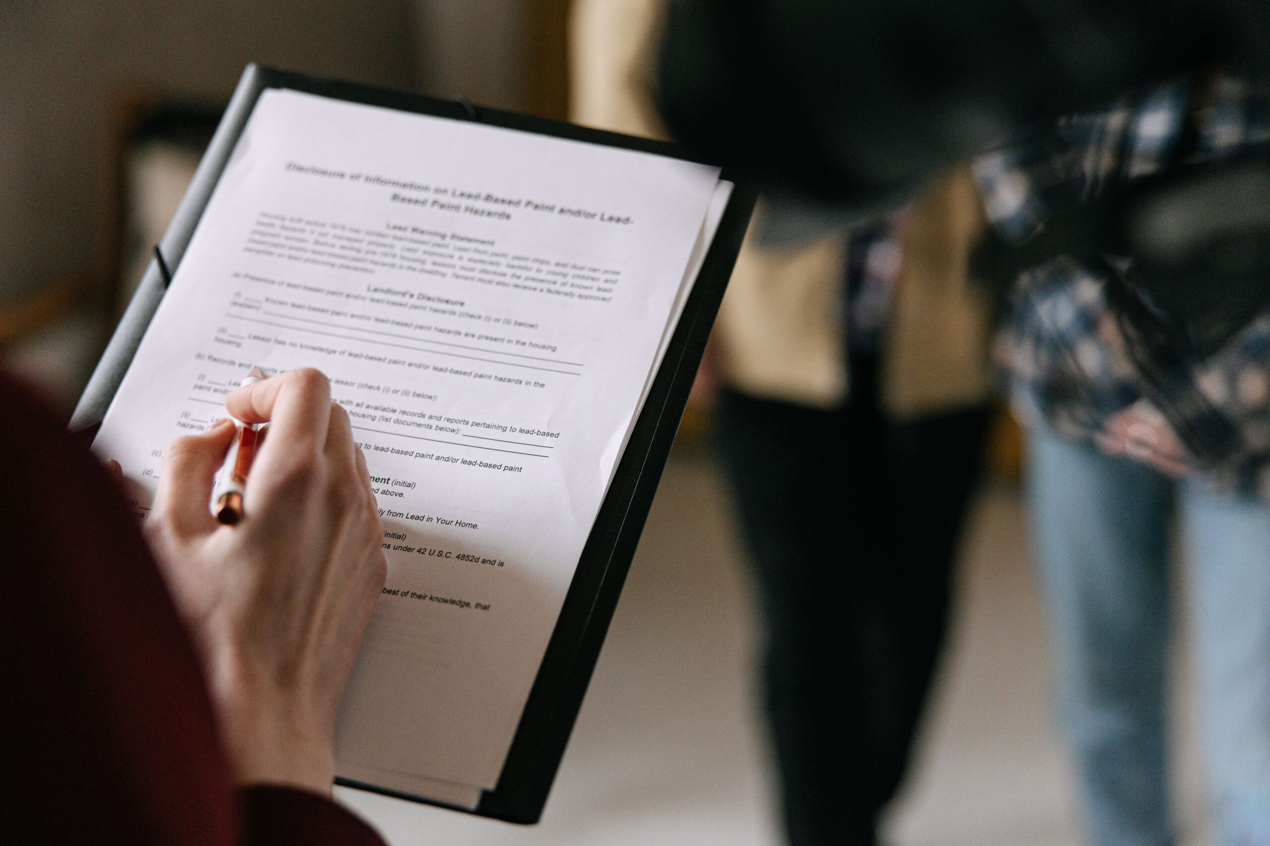 Stock photo flat-lay of a small house model and keys with a mortgage document