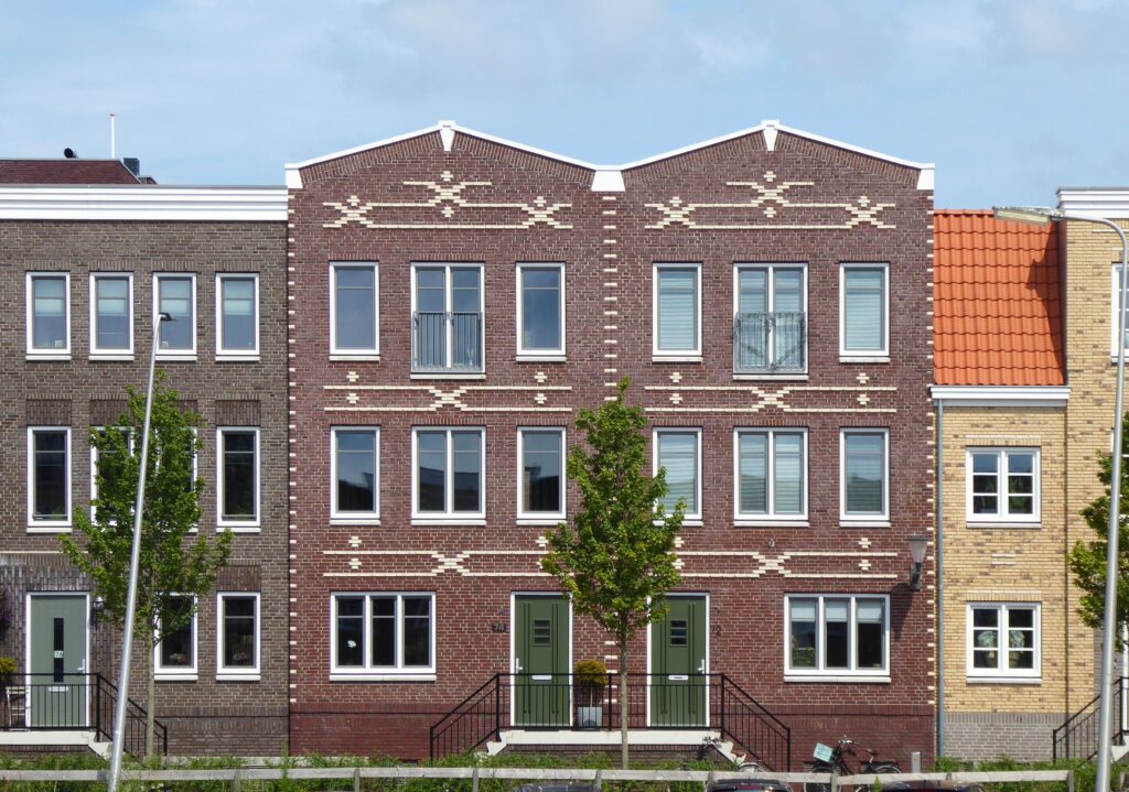 Stock photo of a row of brick multi-family houses with a green lawn