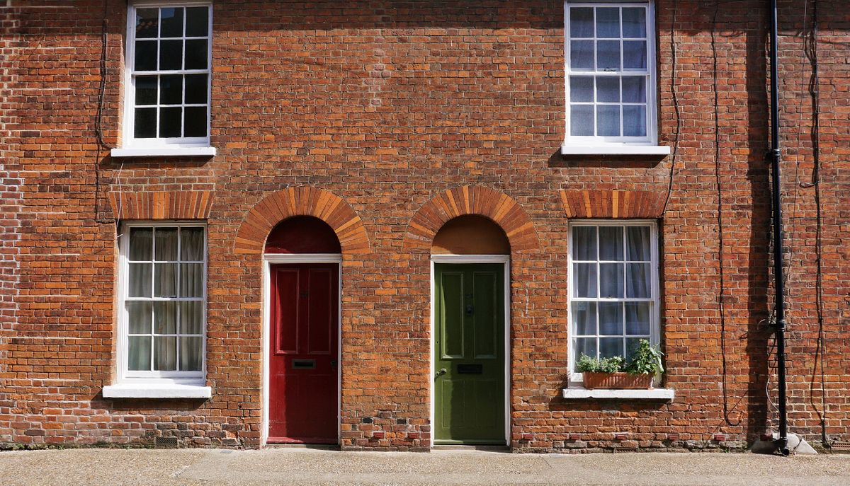 Stock photo of brick rowhouses with red and green doors