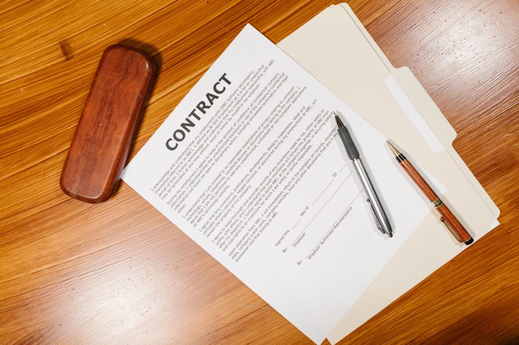 Stock photo of a printed contract with a pen and stamp on a wooden desk