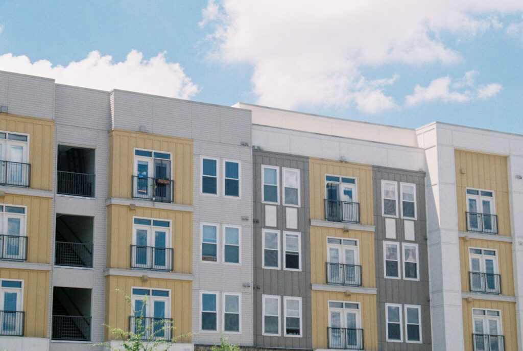 Stock photo of a mid-rise apartment building with balconies against a blue sky