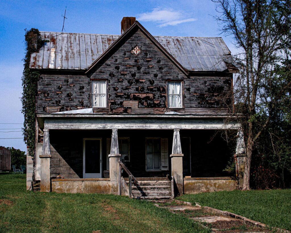 Stock photo of an old stone farmhouse with a sagging front porch