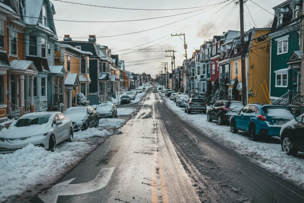 Stock photo of a residential street of houses and parked cars after snowfall