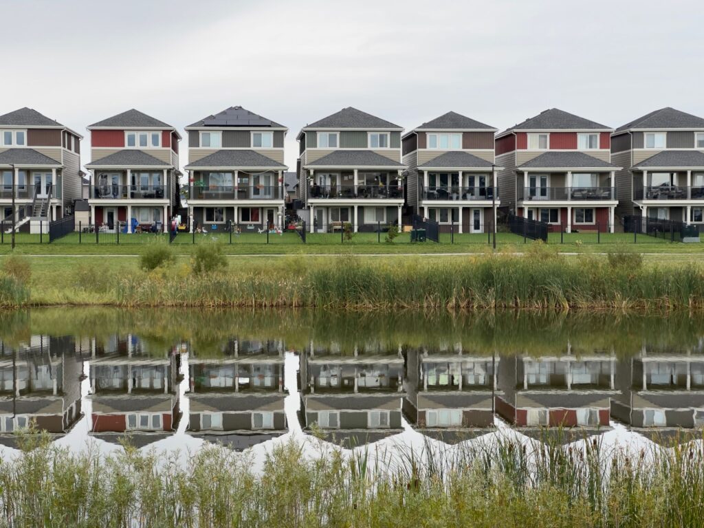 Stock photo of a row of townhouses reflected in a pond