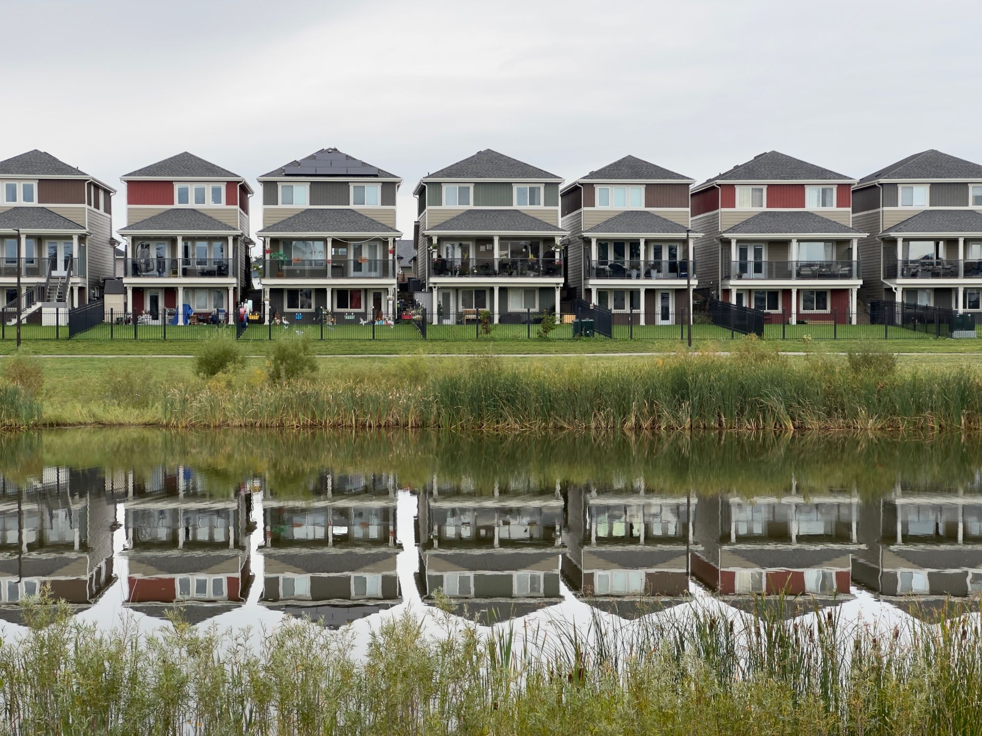 Stock photo of a row of townhouses reflected in a pond