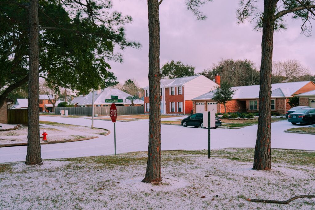 Stock photo of single-family homes on a suburban street with light snow