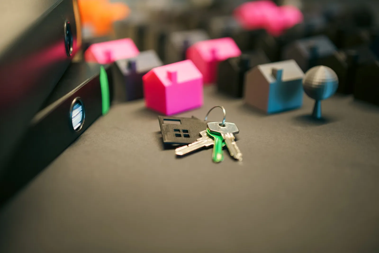 Miniature model houses and a set of keys on a desk