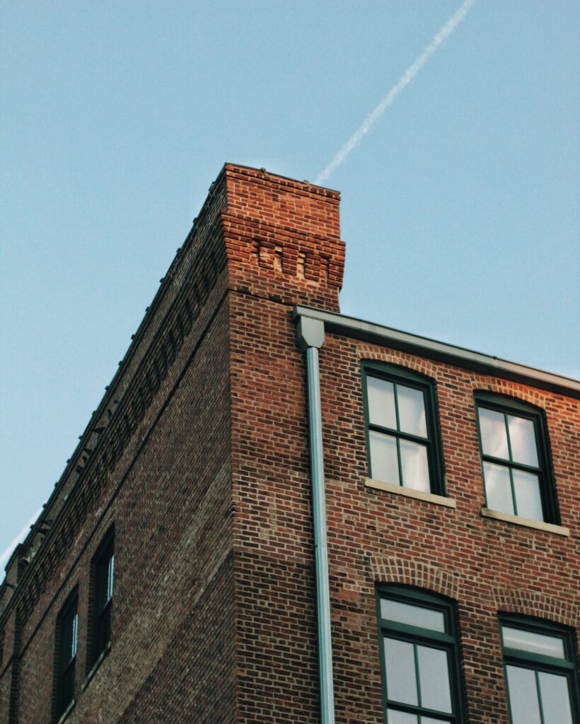 Low-angle view of a classic brick apartment building against a clear blue sky