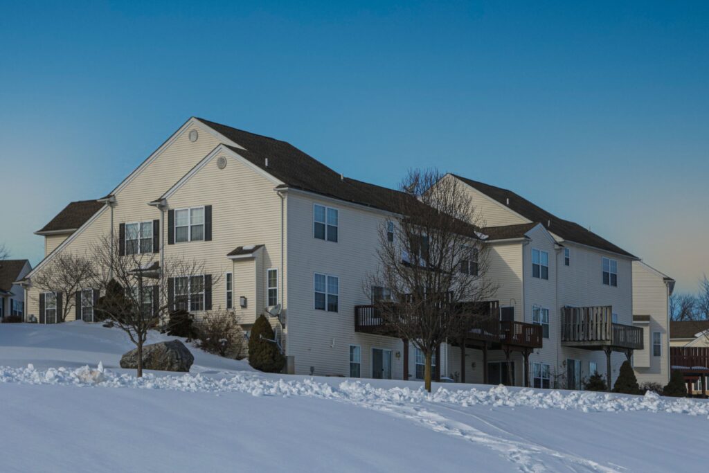 Snow-covered brick multi-unit house on a residential street in Easton, Pennsylvania