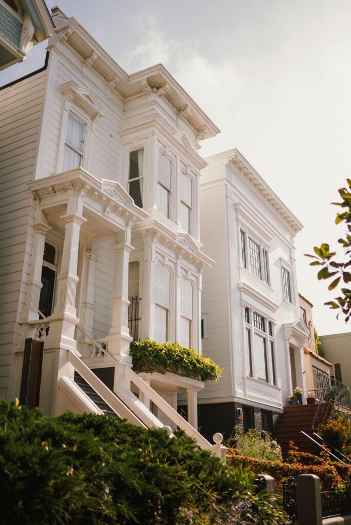 Row of white Victorian townhouses on a sunny San Francisco street