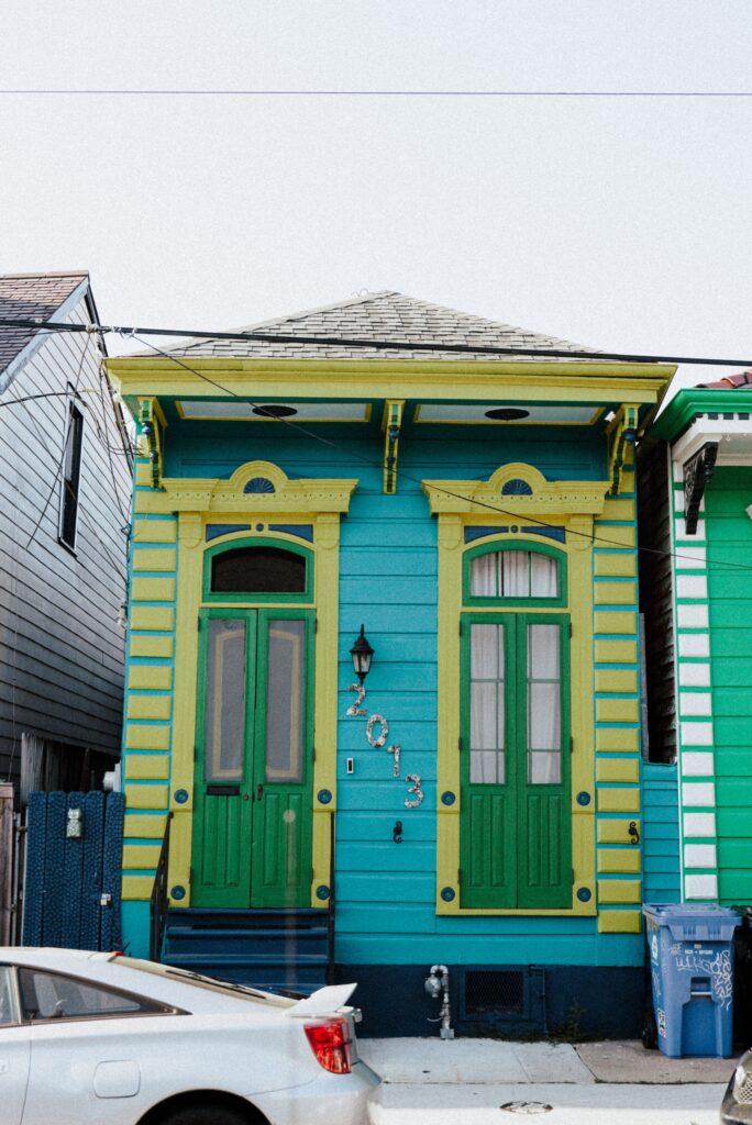 Blue and green New Orleans shotgun house facade with classic trim