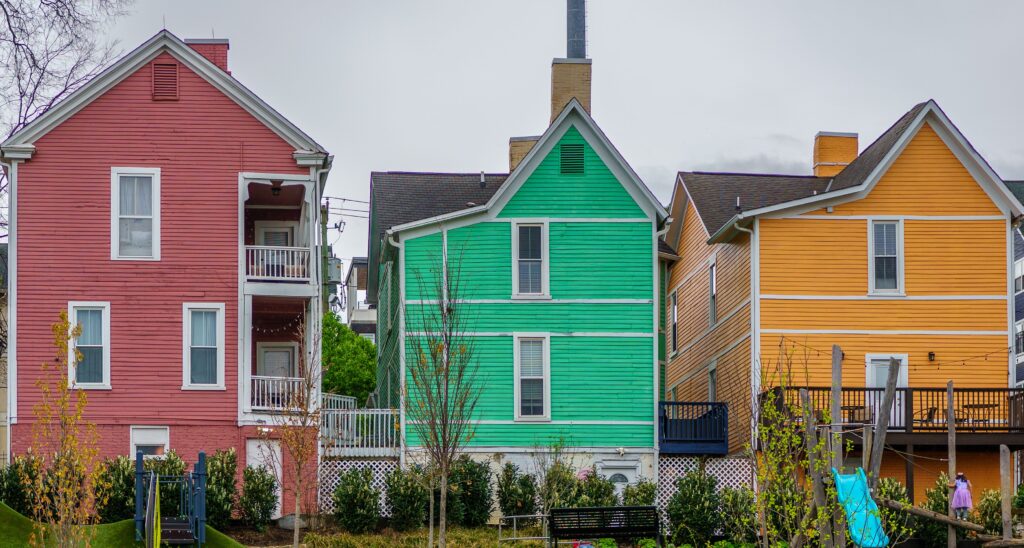 Brightly coloured houses on a Knoxville, Tennessee neighborhood street under a cloudy sky