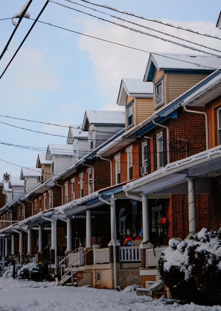 Row of brick houses on a residential street under fresh snowfall
