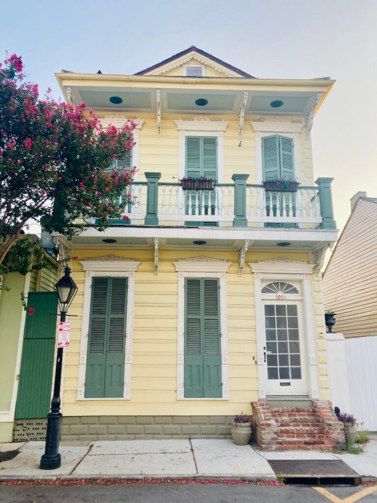 Yellow Creole cottage with traditional shutters in a historic New Orleans neighborhood