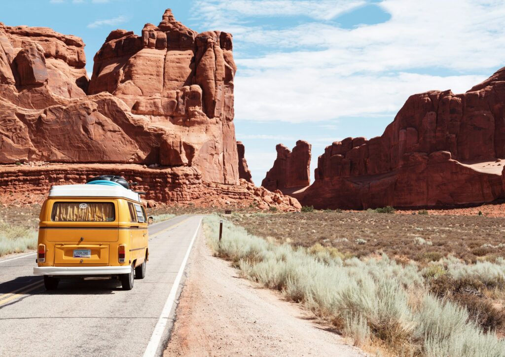 Yellow Volkswagen van on a desert highway near Arches National Park, Moab, Utah