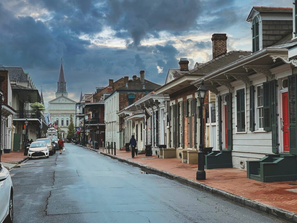 Street lined with row houses under a cloudy sky in New Orleans