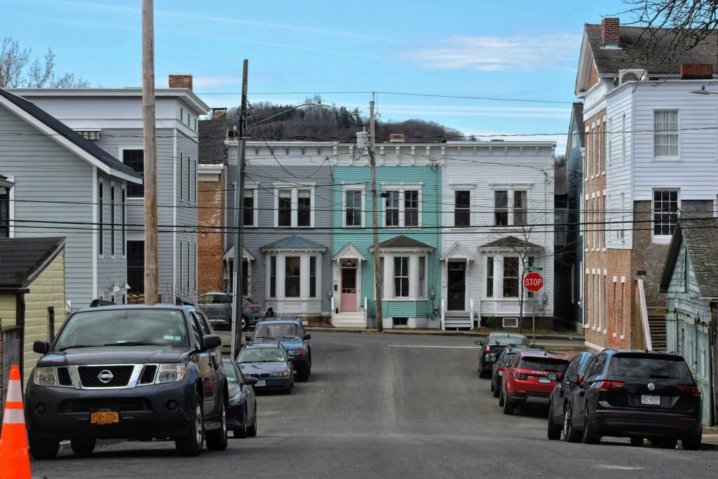Residential street of attached townhouses painted in different colours in Hudson, New York