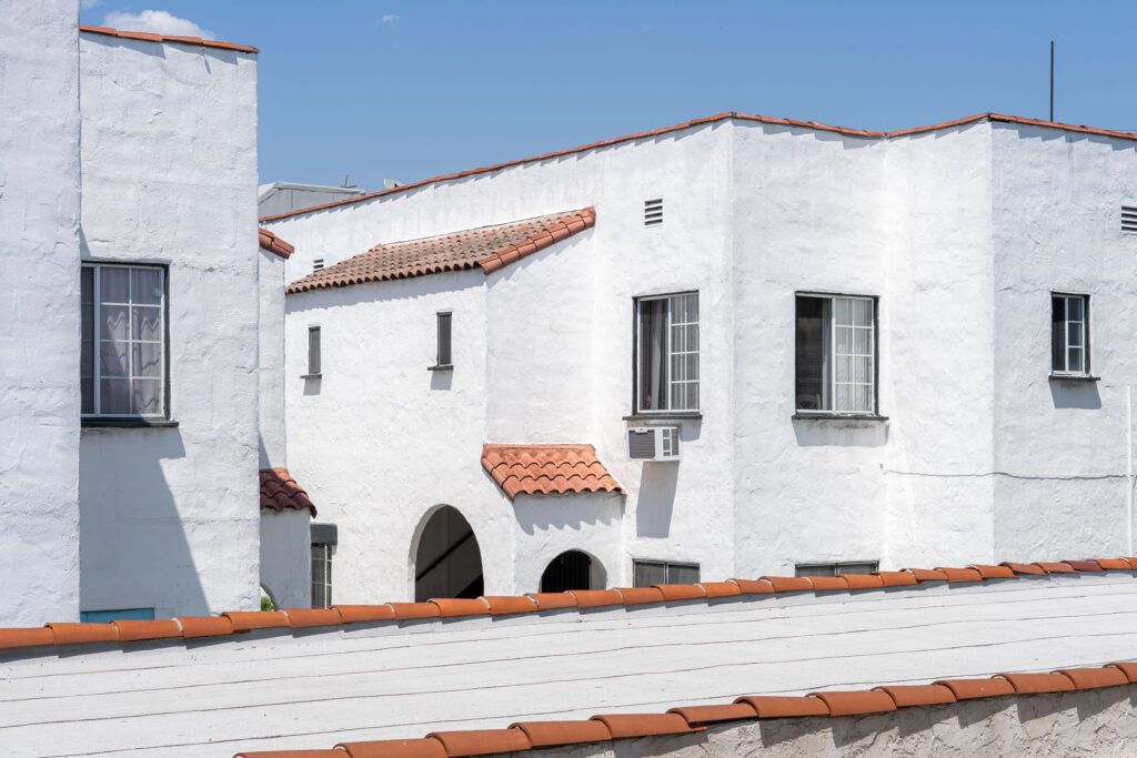 White stucco apartment buildings with red tile roofs in sunlight in Los Angeles