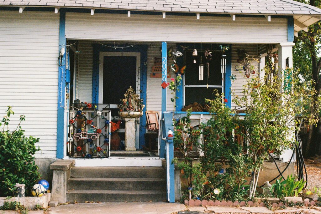 Front porch with blue trim, potted plants and wind chimes on an older house in Austin, Texas