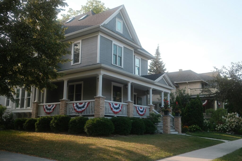 A gray two-story house with a wide front porch