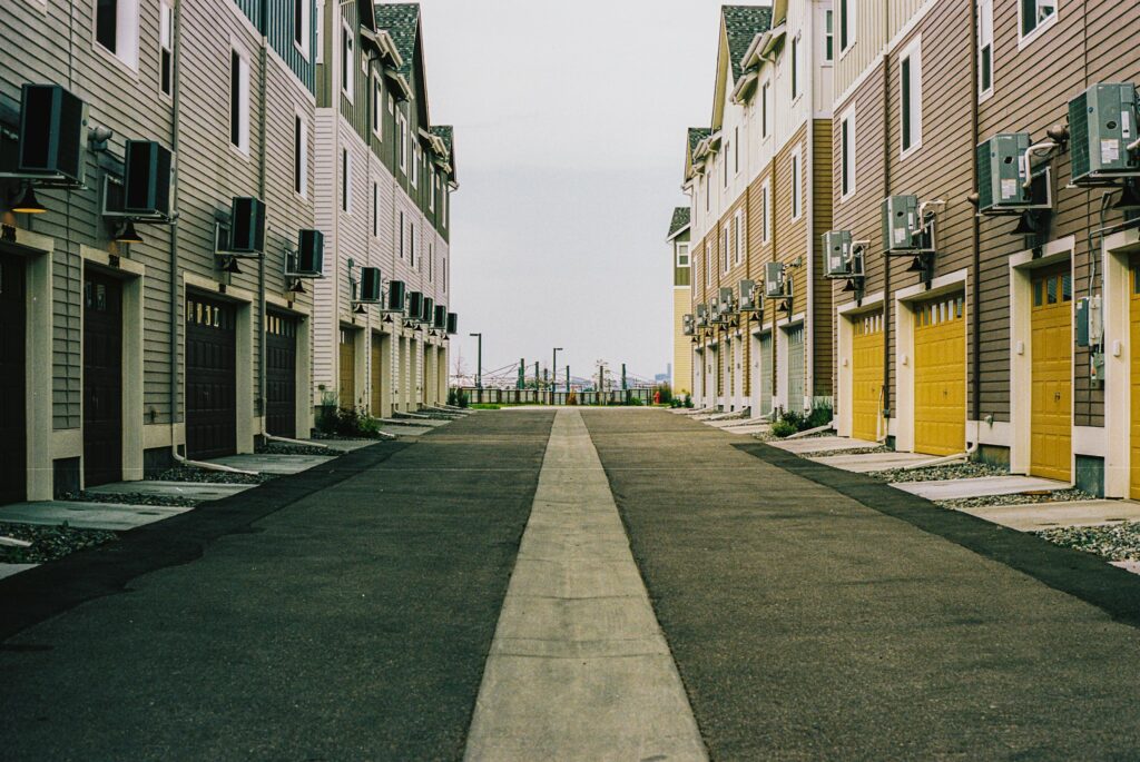 Street lined with attached row houses with yellow garage doors in Denver, Colorado