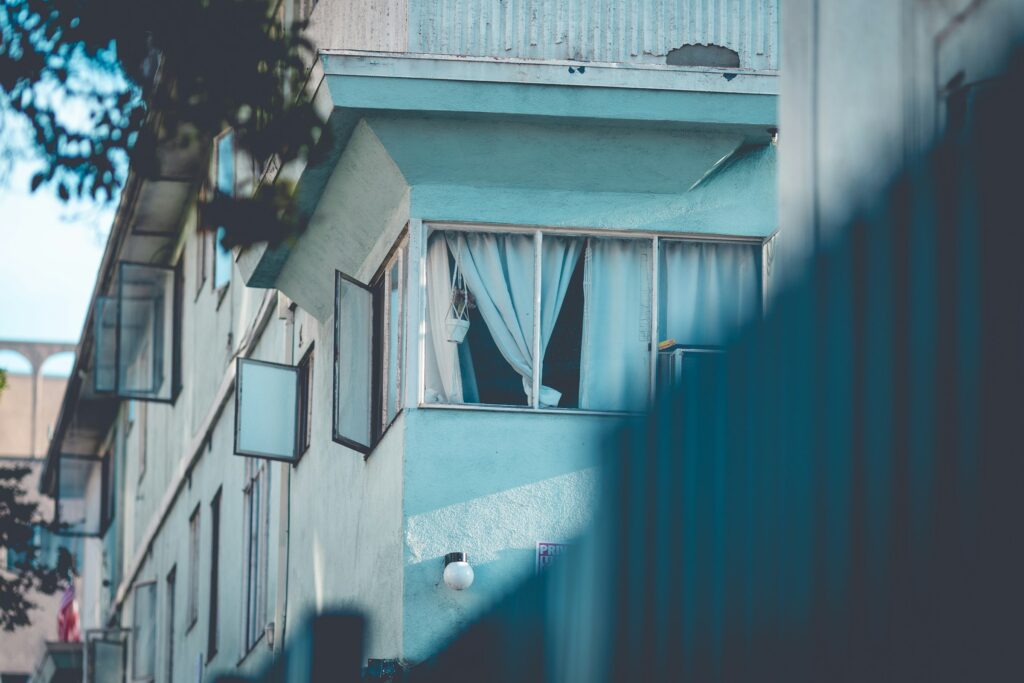 Small teal apartment building with windows and balconies in Los Angeles