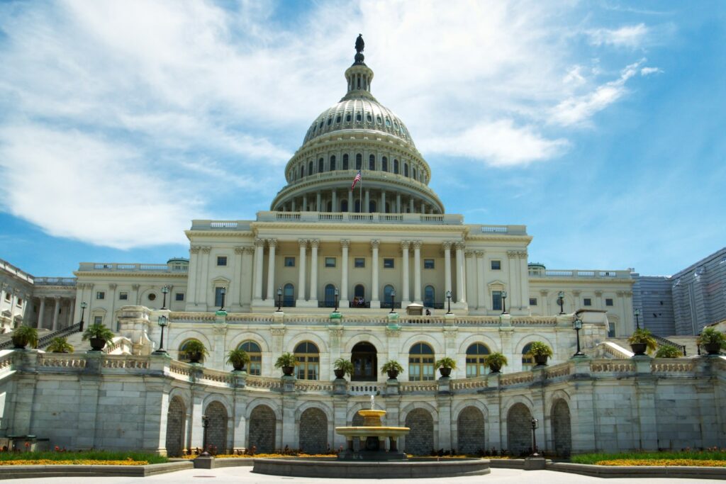 The U.S. Capitol building in daylight with a fountain in front